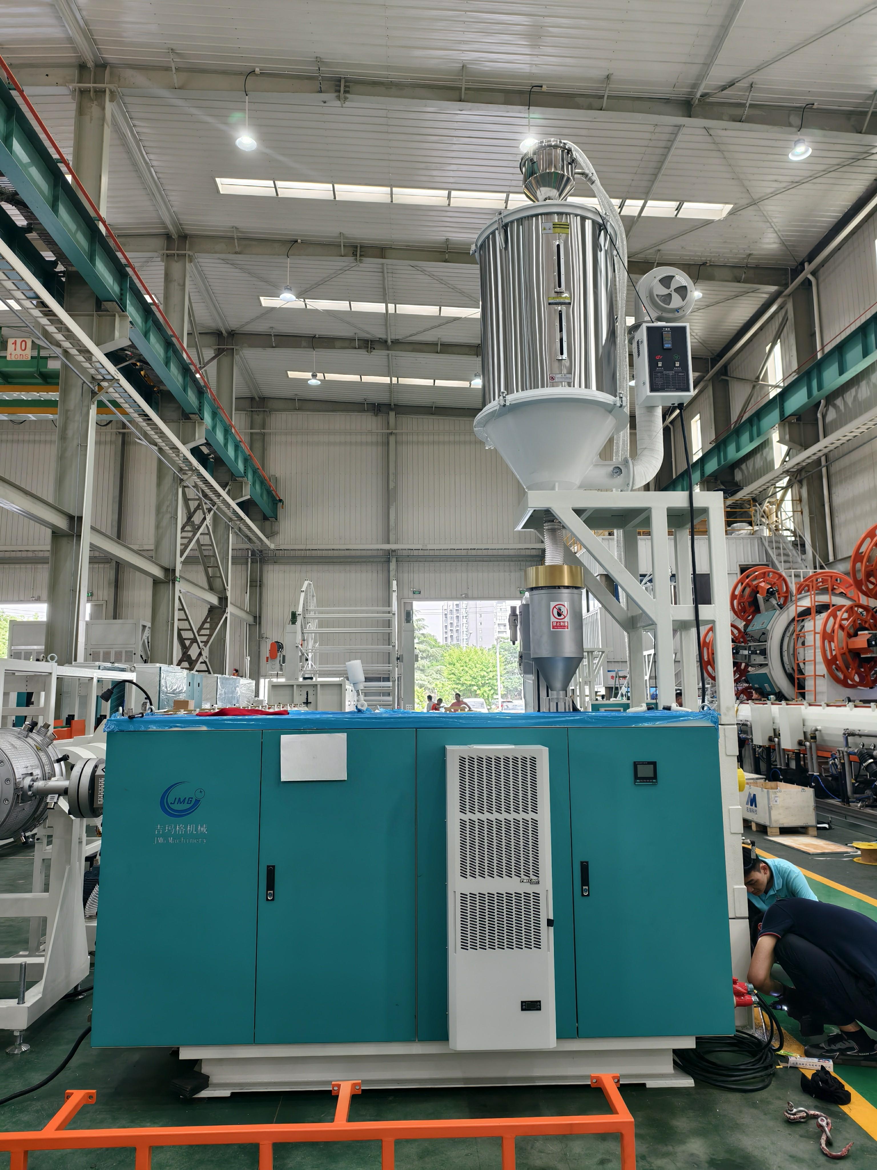Factory floor photo showing a completed JMGDZ150 line producing pipe in real operation