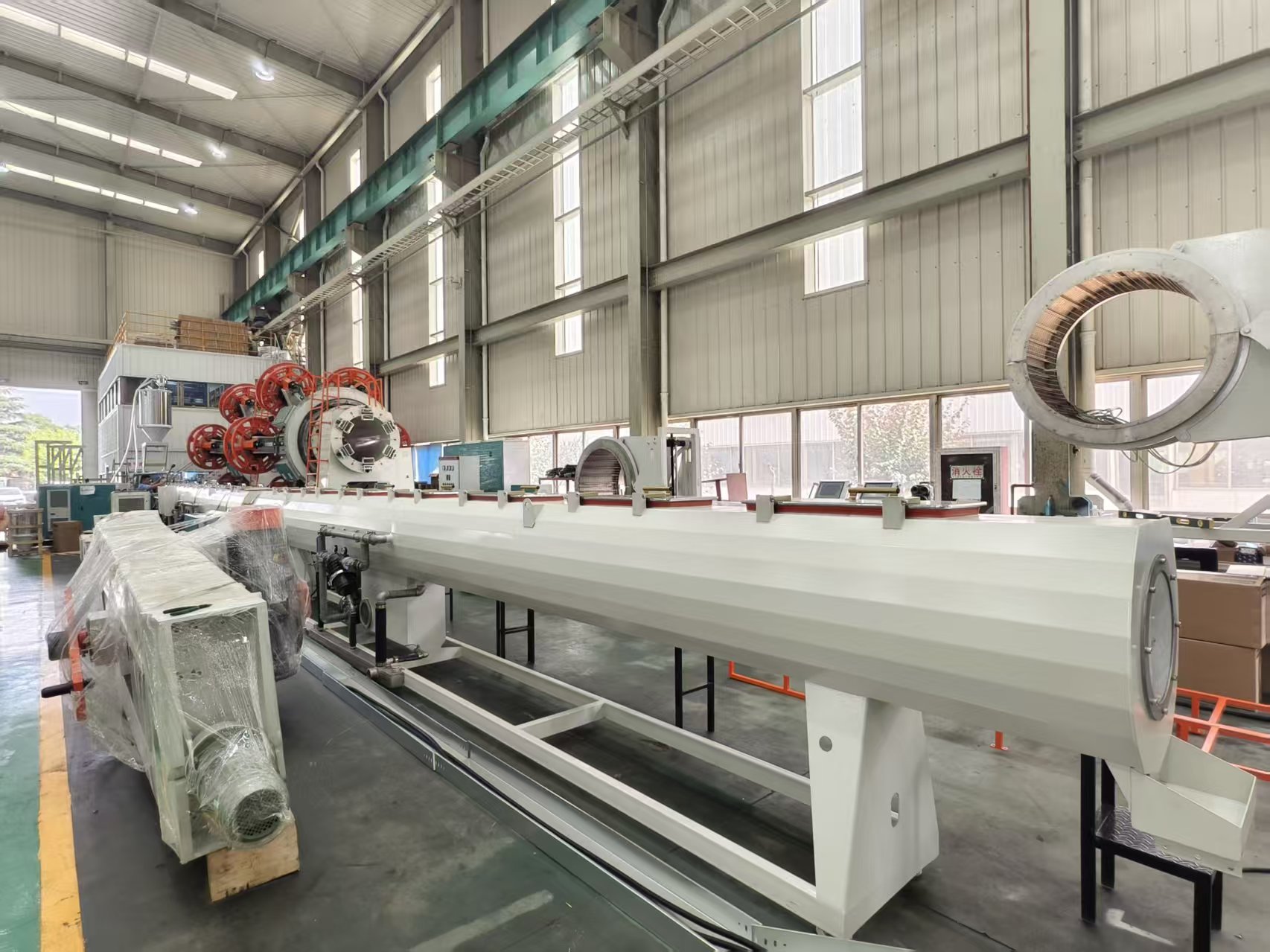 Jinglei Machinery vacuum calibration tank installed on a full pipe extrusion line for PVC pipe production